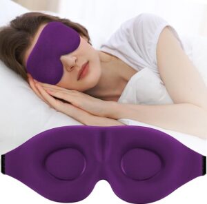 Una mujer que lleva una máscara para dormir de color púrpura yace de lado en la cama. Debajo de ella hay una imagen en primer plano de la máscara para dormir.